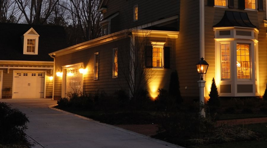 Residential home with illuminated windows and a driveway, highlighting Aptus Home Services home maintenance focus.