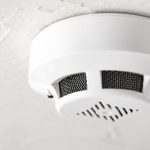 Smoke detector mounted on ceiling, emphasizing home safety and functionality, relevant to smoke alarm installation and maintenance guidance.